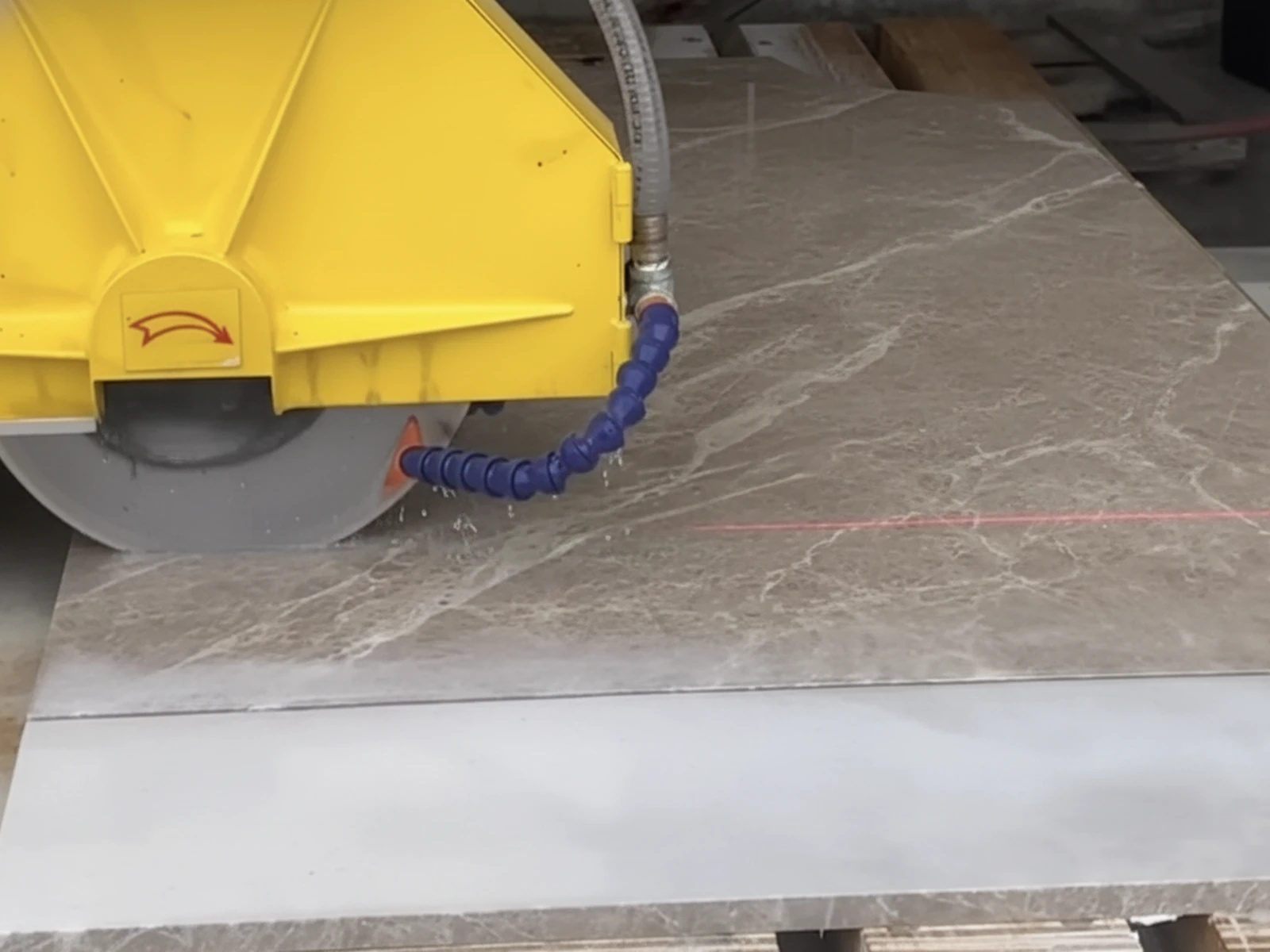 Machine de débitage CNC en action dans l'atelier ARCHIMAR — tête diamantée, refroidissement eau