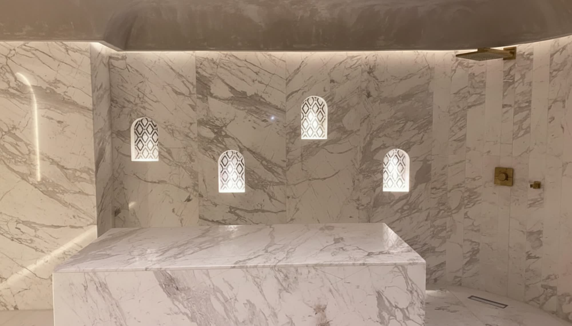 Hammam hôtelier en marbre Calacatta, niches cintrées mashrabiya — ARCHIMAR